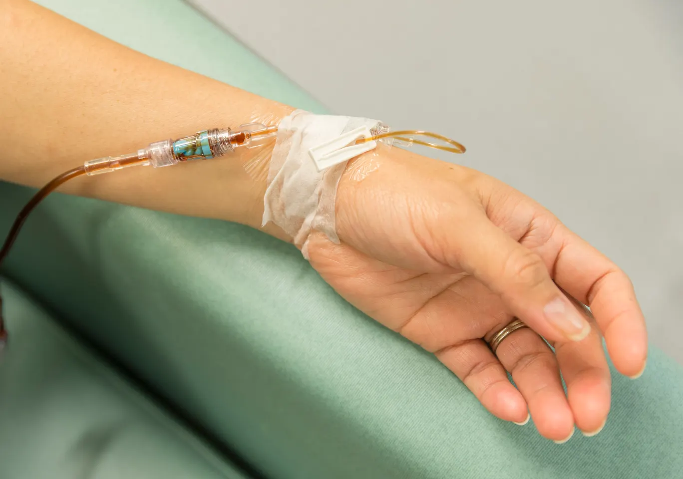 Kroplówki witaminowe Gorzów Wielkopolski: dłoń z wenflonem i linią infuzyjną na podkładzie